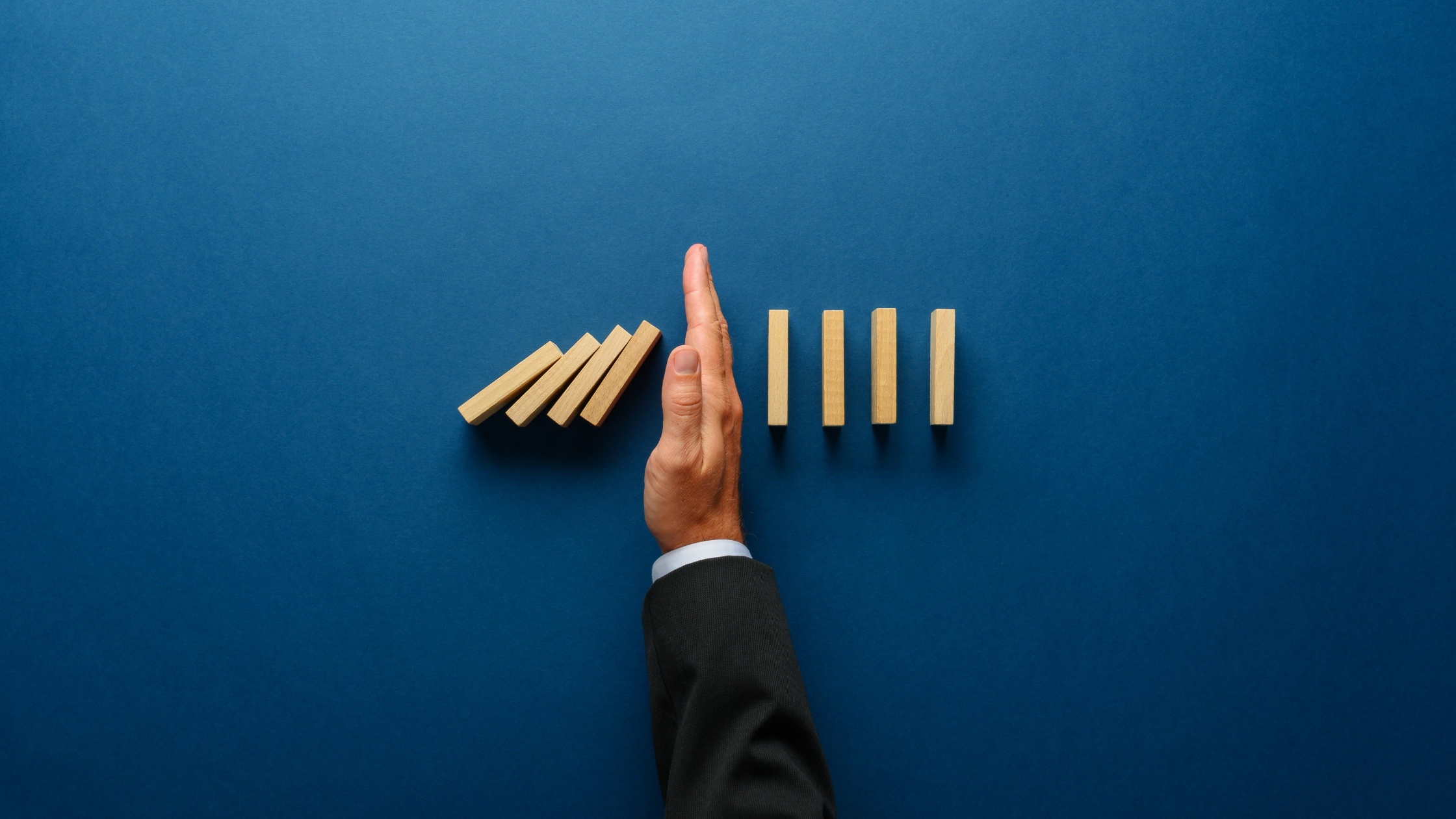 a hand placed between dominoes