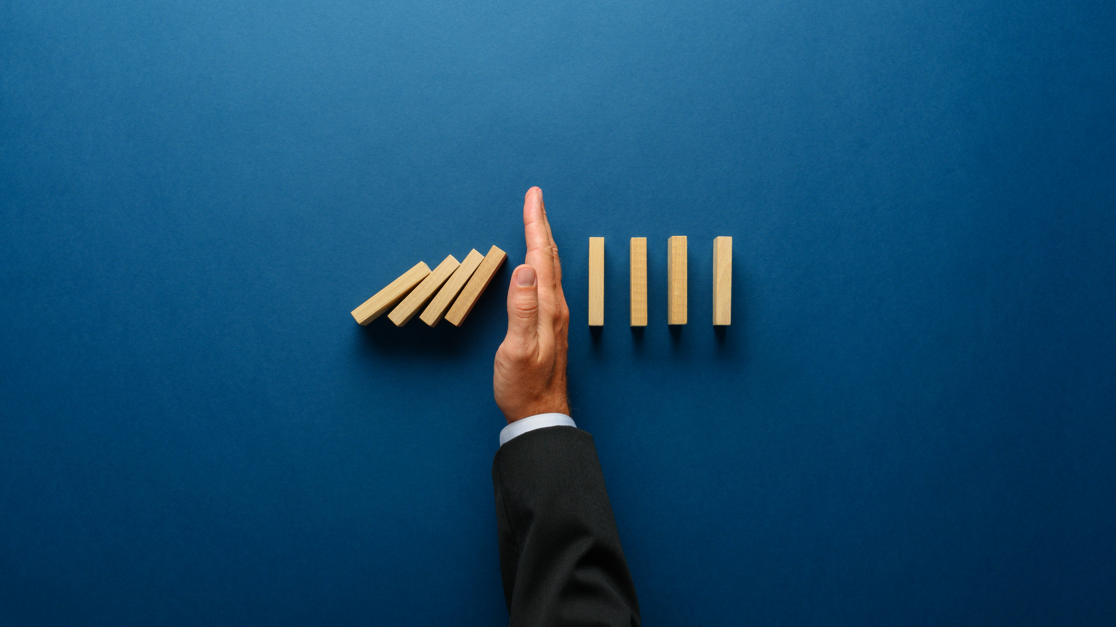 a hand placed between dominoes 