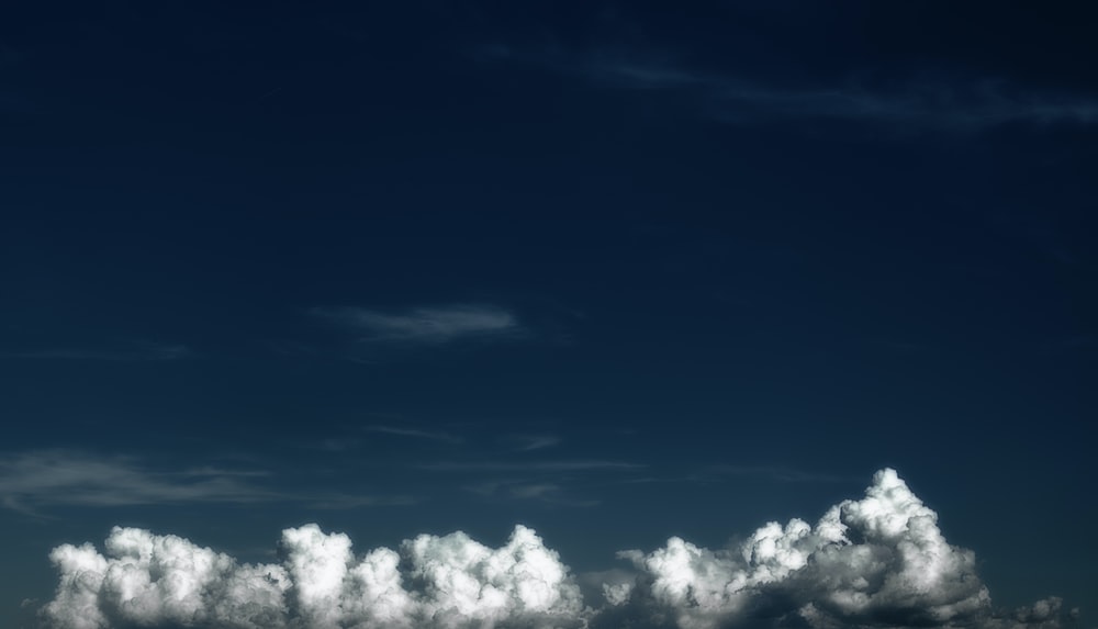 White clouds at the bottom of a dark blue sky