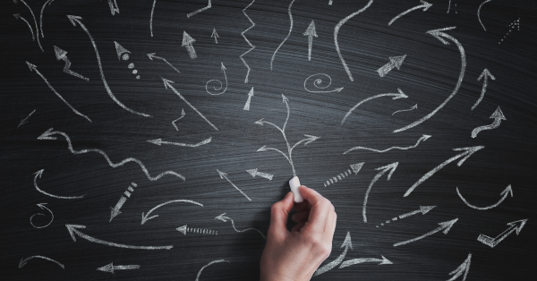 a hand writing different arrows on a chalkboard